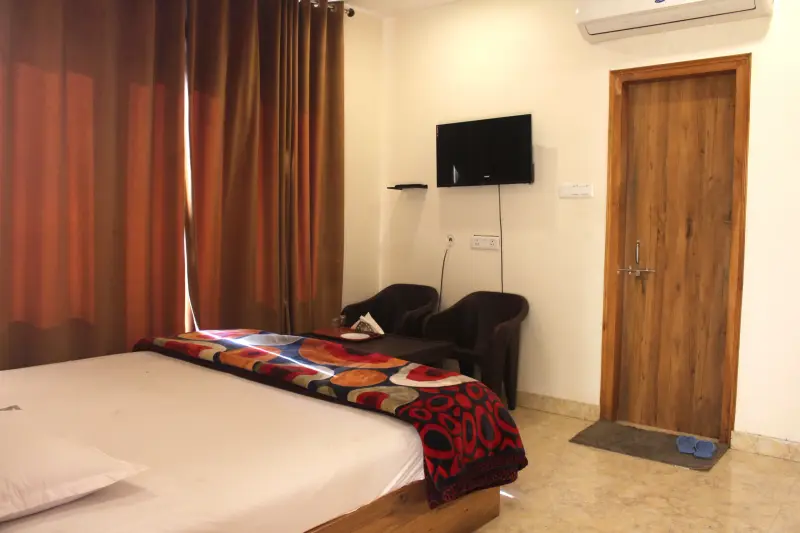 Balcony Room bed with television, AC and curtains.
