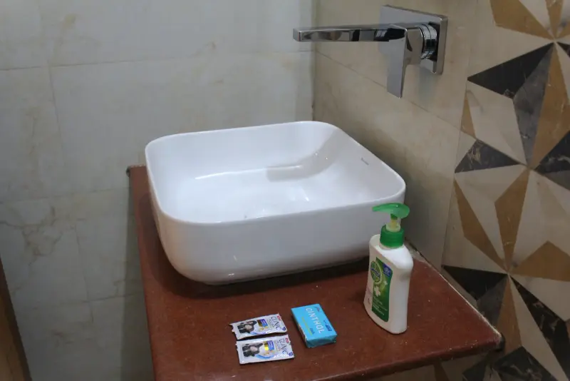Bathroom vanity with basin and toiletries.