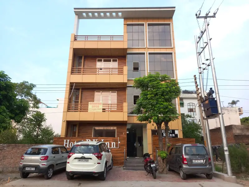 Hotel RK Inn building facade with parked cars in the forecourt.